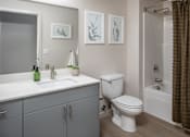 Thumbnail 15 of 34 - A white toilet sits next to a sink in a bathroom.