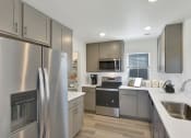 Thumbnail 41 of 51 - a kitchen with stainless steel appliances and white counter tops