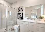Thumbnail 25 of 27 - A white bathroom with a toilet, sink, and mirror.