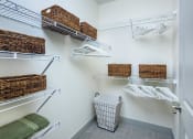 Thumbnail 26 of 29 - a closet with shelves and baskets and a basket in the corner