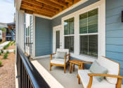 Thumbnail 28 of 29 - a covered porch with two chairs and a table