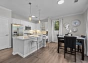 Thumbnail 2 of 21 - a kitchen with an island and a table with chairs