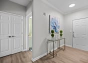 Thumbnail 16 of 21 - a hallway with white doors and a table with plants