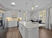 Thumbnail 15 of 21 - a white kitchen with a large island and stainless steel appliances