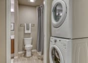 Thumbnail 8 of 30 - a washer and dryer in a bathroom with a toilet and a shower