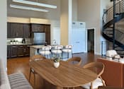 Thumbnail 8 of 28 - A modern kitchen with a dining table and chairs.