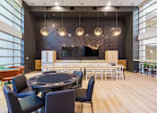Thumbnail 11 of 28 - a large room with a round table and chairs and a bar in the background
