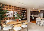 Thumbnail 4 of 28 - A modern kitchen with a wooden wall panel and a dining table with chairs.