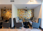 Thumbnail 16 of 28 - a living room with couches and chairs and a wall with geometric tiles