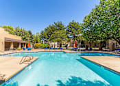 Thumbnail 40 of 51 - A large swimming pool surrounded by trees and sun loungers.