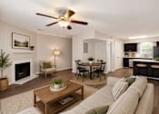 Thumbnail 48 of 55 - A living room with a fireplace, a dining table, and a kitchen area in the background.