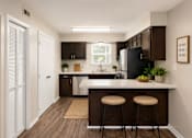 Thumbnail 54 of 55 - A kitchen with a white door and a black fridge.