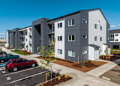 Thumbnail 23 of 27 - Modern apartment complex with a parking lot in front at The Arvon, Vancouver