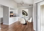 Thumbnail 3 of 22 - A modern kitchen with a dining table and chairs.