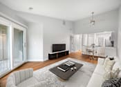 Thumbnail 2 of 22 - A modern living room with a white sofa and a coffee table.