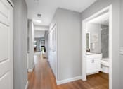 Thumbnail 8 of 22 - A white bathroom with a wooden floor and white walls.