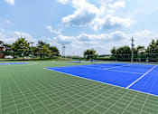 Thumbnail 14 of 22 - A tennis court with a blue surface and white lines.