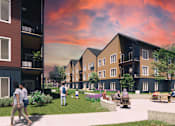 Thumbnail 2 of 10 - A group of people are walking in a courtyard between two apartment buildings.