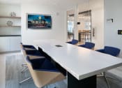 Thumbnail 20 of 30 - a conference room with a long white table and blue chairs