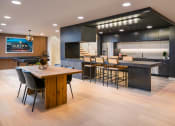 Thumbnail 16 of 30 - the kitchen and dining area of a modern home with a wood floor and black cabinets