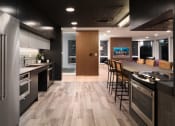 Thumbnail 15 of 30 - a kitchen with stainless steel appliances and a large island with chairs
