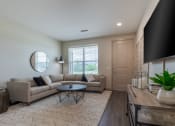 Thumbnail 10 of 41 - a living room with a couch and a table and a tv