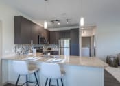 Thumbnail 6 of 41 - a kitchen with a granite counter top with white chairs