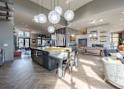 Thumbnail 34 of 41 - A modern kitchen with a large island and pendant lights.