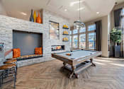 Thumbnail 36 of 41 - A pool table is in the middle of a room with a fireplace and a chair.