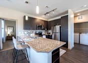 Thumbnail 29 of 41 - A kitchen with a granite countertop and stainless steel appliances.