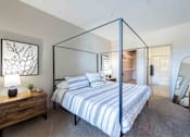 Thumbnail 31 of 41 - A bedroom with a four poster bed and a wooden nightstand.