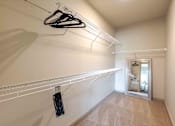 Thumbnail 19 of 41 - A hallway with a white wall and a black hanger on the rack.