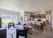 Thumbnail 16 of 26 - A modern kitchen with a bar stool and a dining table.