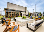 Thumbnail 17 of 26 - A patio with a hot tub and chairs.