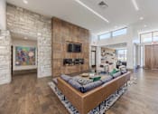Thumbnail 12 of 26 - A modern living room with a stone fireplace and a large sectional sofa.
