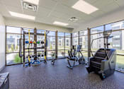 Thumbnail 15 of 26 - A gym with a treadmill, elliptical trainer, and other exercise equipment.
