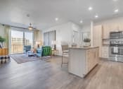Thumbnail 2 of 47 - Kitchen looking out to living room- white cupboards, hardwood floors, stainless appliances