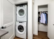 Thumbnail 29 of 42 - A white washing machine and dryer in a small laundry room.