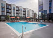 Thumbnail 21 of 35 - Outdoor pool with lounge seating and umbrellas