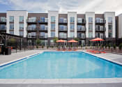 Thumbnail 22 of 35 - Outdoor pool with lounge seating and umbrellas from a different angle