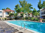 Thumbnail 6 of 26 - A swimming pool surrounded by sun loungers and trees at The Casas Apartments, California, 92126
