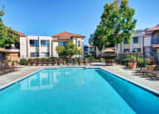 Thumbnail 1 of 26 - A swimming pool in front of apartment buildings. at The Casas Apartments, San Diego