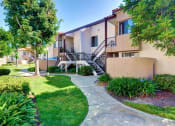 Thumbnail 8 of 26 - A building with a staircase and a tree in front of it at The Casas Apartments, San Diego, California