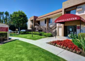 Thumbnail 10 of 26 - The Casas Leasing Center is a building with a red awning and a sign in front of it at The Casas Apartments, San Diego, CA