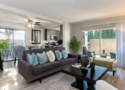 Thumbnail 2 of 26 - A living room with a brown couch and a coffee table at The Casas Apartments, San Diego