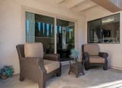 Thumbnail 15 of 26 - Two chairs and a table are on a patio at The Casas Apartments, San Diego, 92126