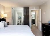 Thumbnail 19 of 26 - A bedroom with a large bed and a black dresser at The Casas Apartments, California