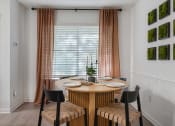 Thumbnail 6 of 23 - a dining area with a wooden table and four chairs