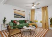 Thumbnail 7 of 23 - a living room with a green couch and yellow curtains