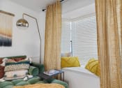 Thumbnail 8 of 23 - a window seat with yellow curtains and a green sofa